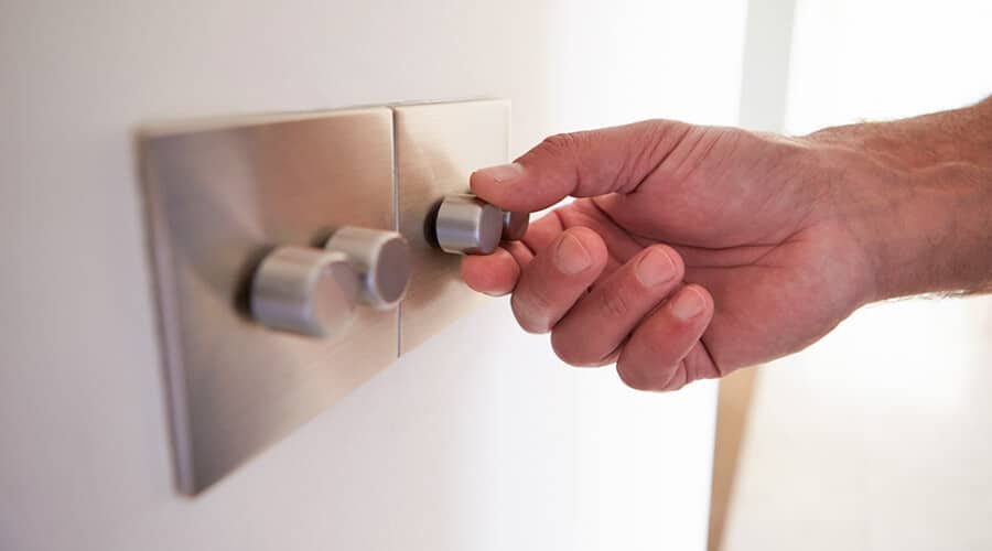 Two dimmer switches with a hand adjusting the lighting level